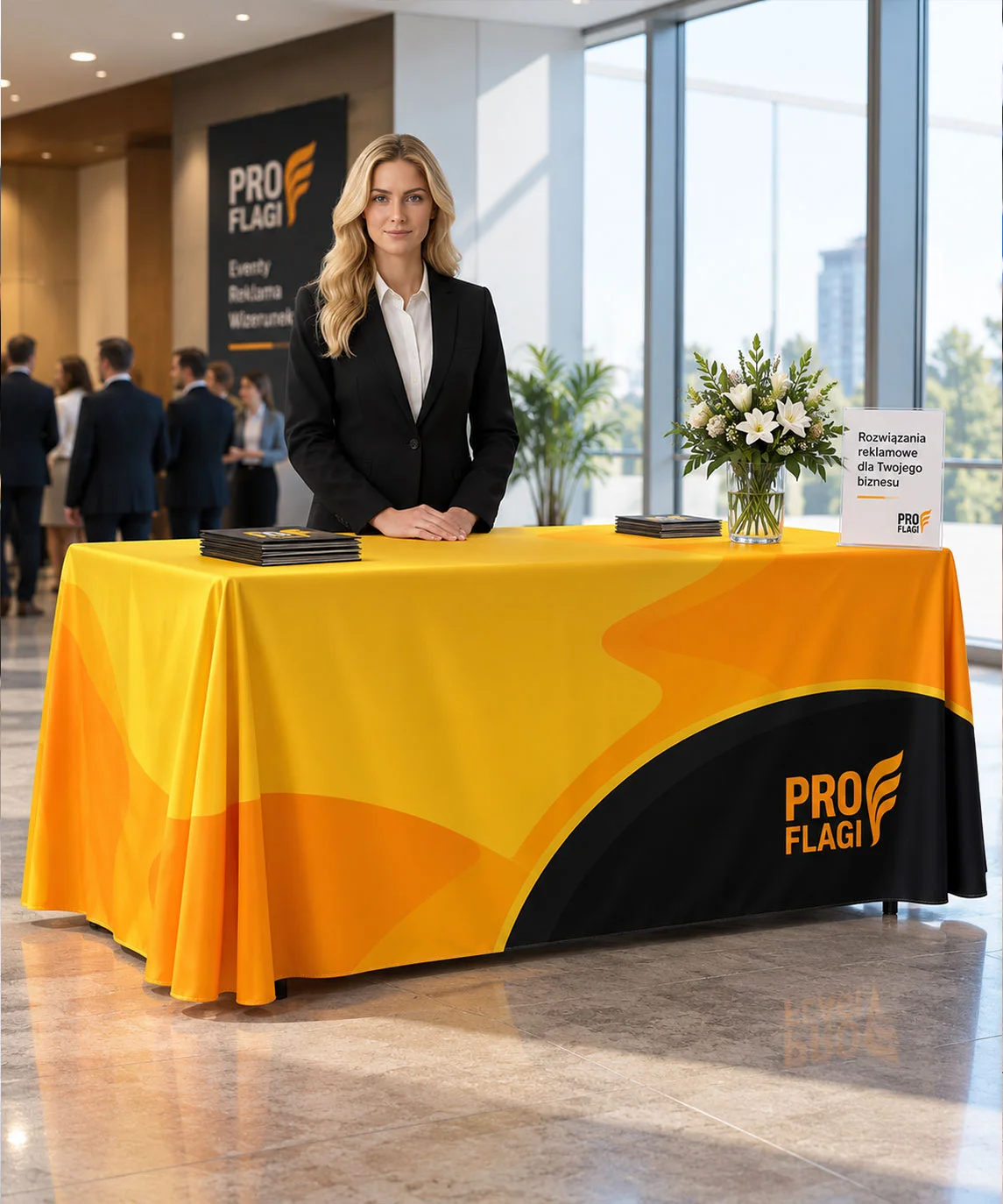 Żółty obrus z logo PROflagi na stole z katalogami podczas wydarzenia firmowego